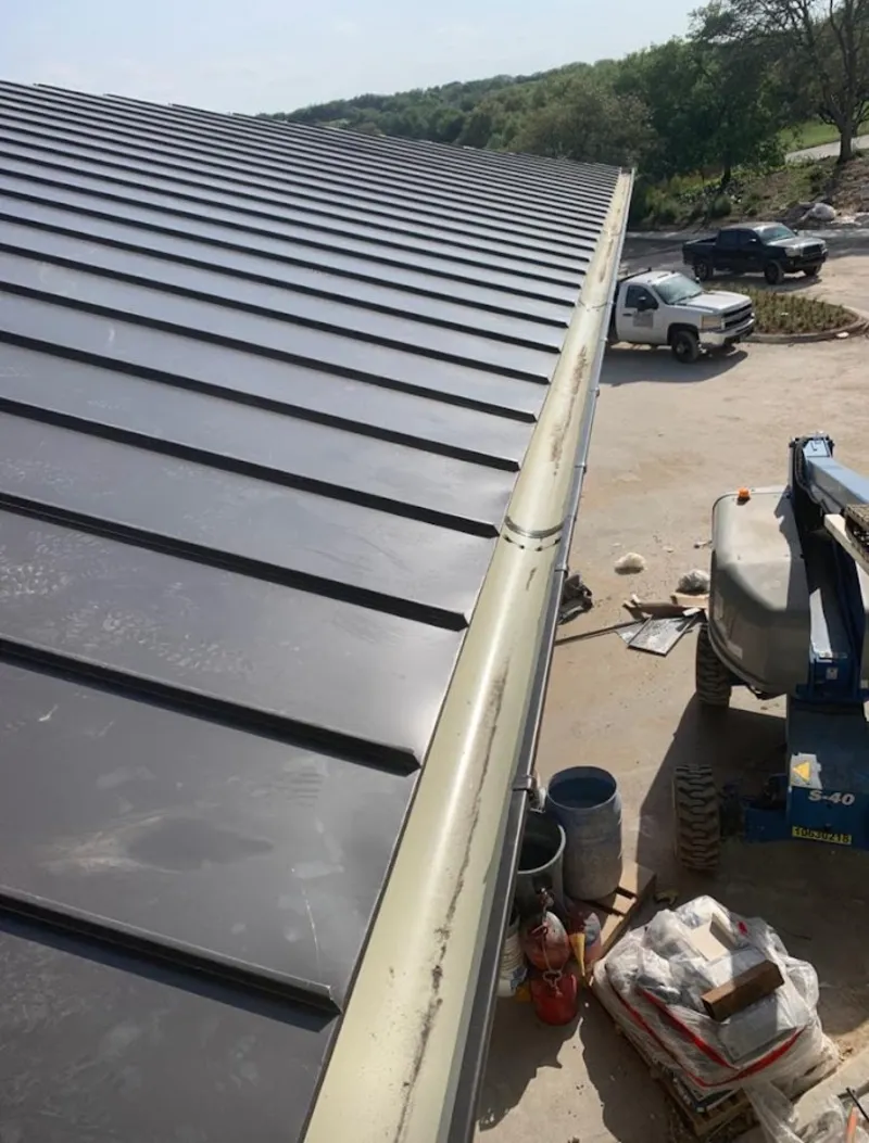 Standing seam panel and gutter detail on a metal roofing jobsite in Jamul